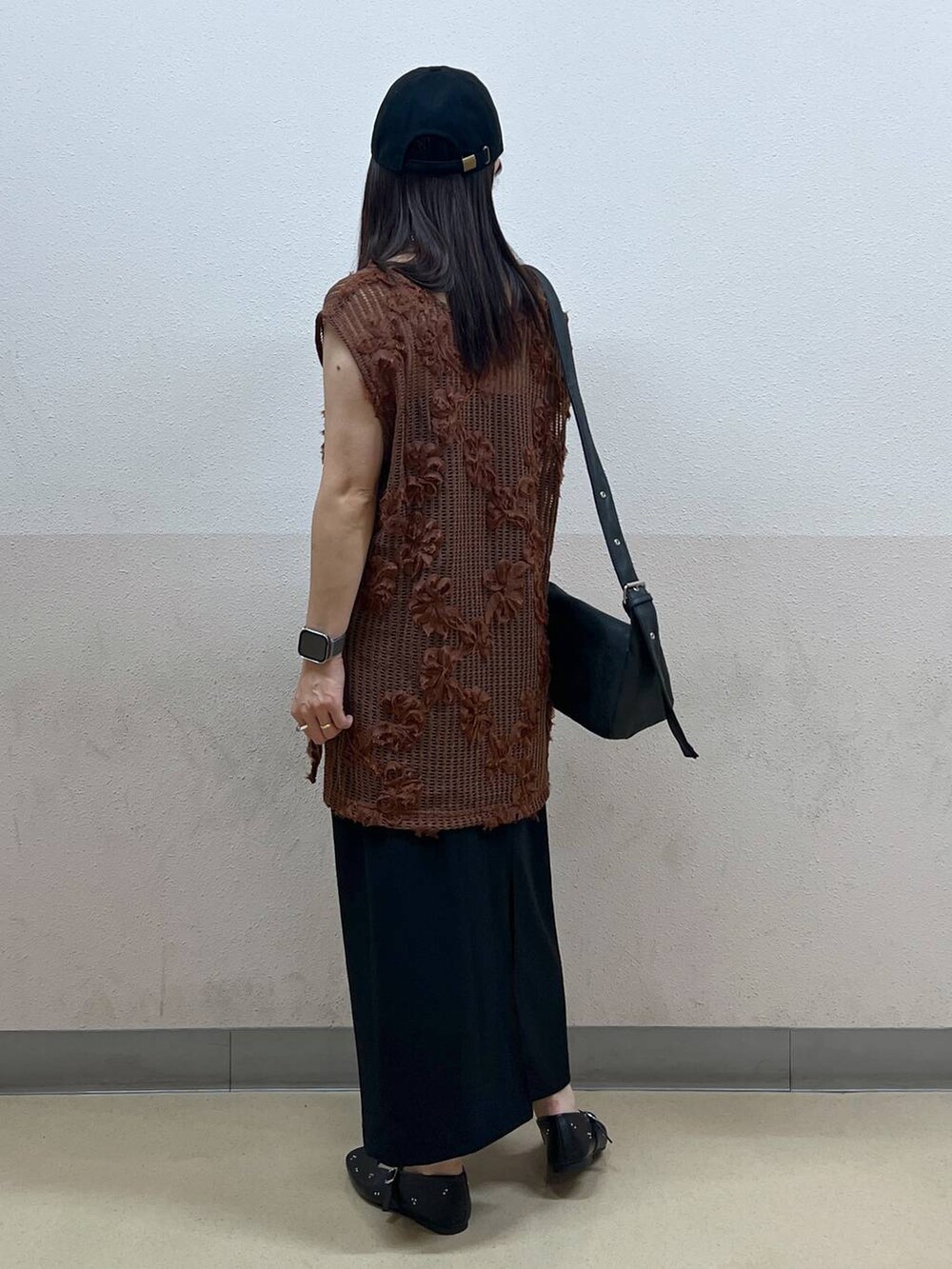 ブラック系のスカート、ブラック系のパンプス、ブラック系のショルダーバッグを着用したレディースの夏コーディネートの3枚目の写真