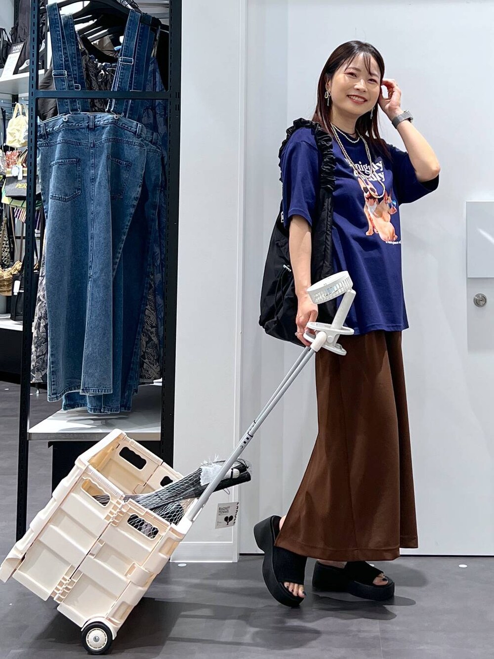 ブラック系のショルダーバッグ、ブルー系のTシャツ/カットソー、グレー系のスポーツグッズを着用したレディースの春コーディネートの2枚目の写真