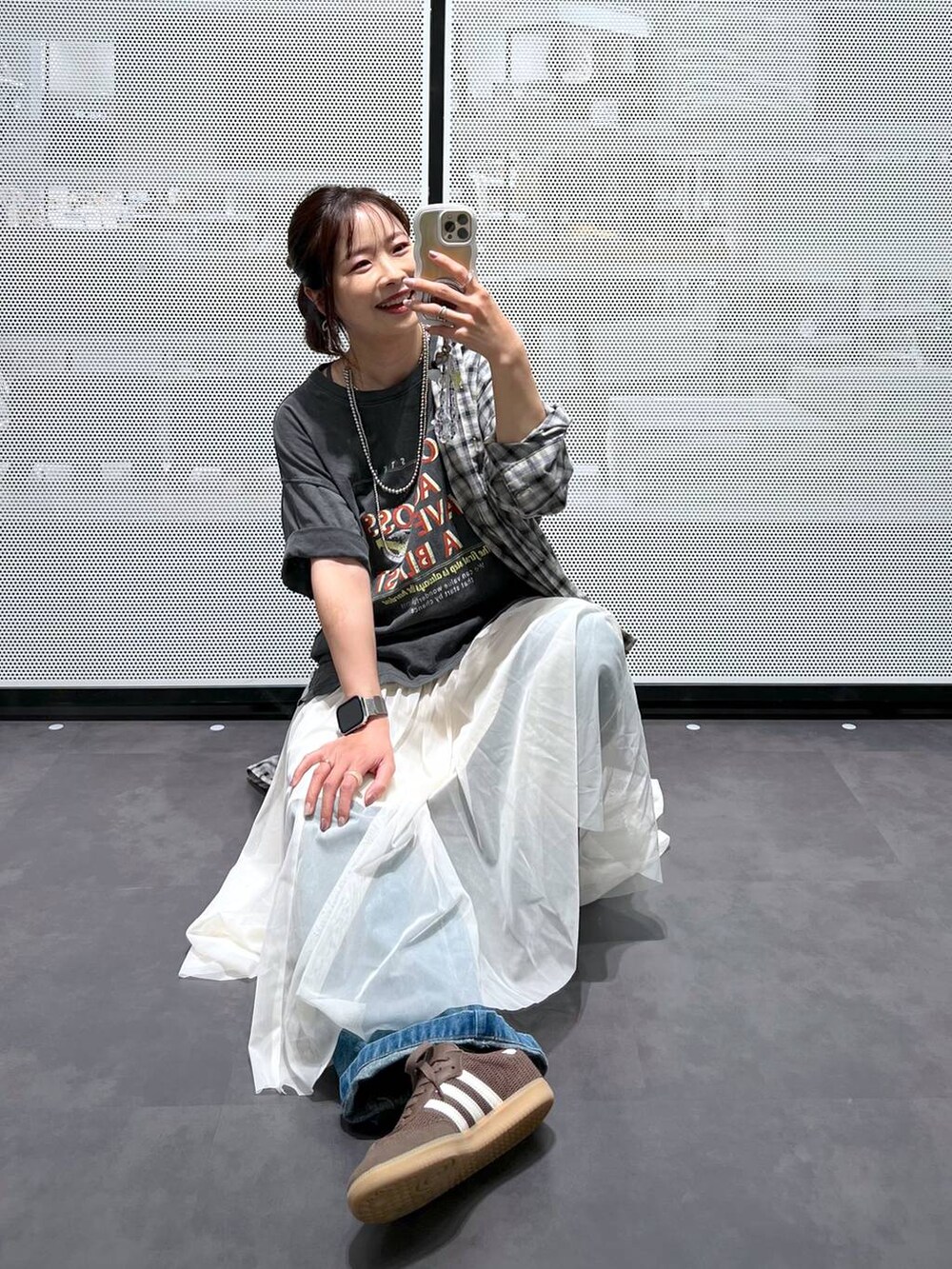 ブルー系のデニムパンツ、ベージュ系のシャツ/ブラウス、ベージュ系のスカートを着用したレディースの春コーディネートの3枚目の写真