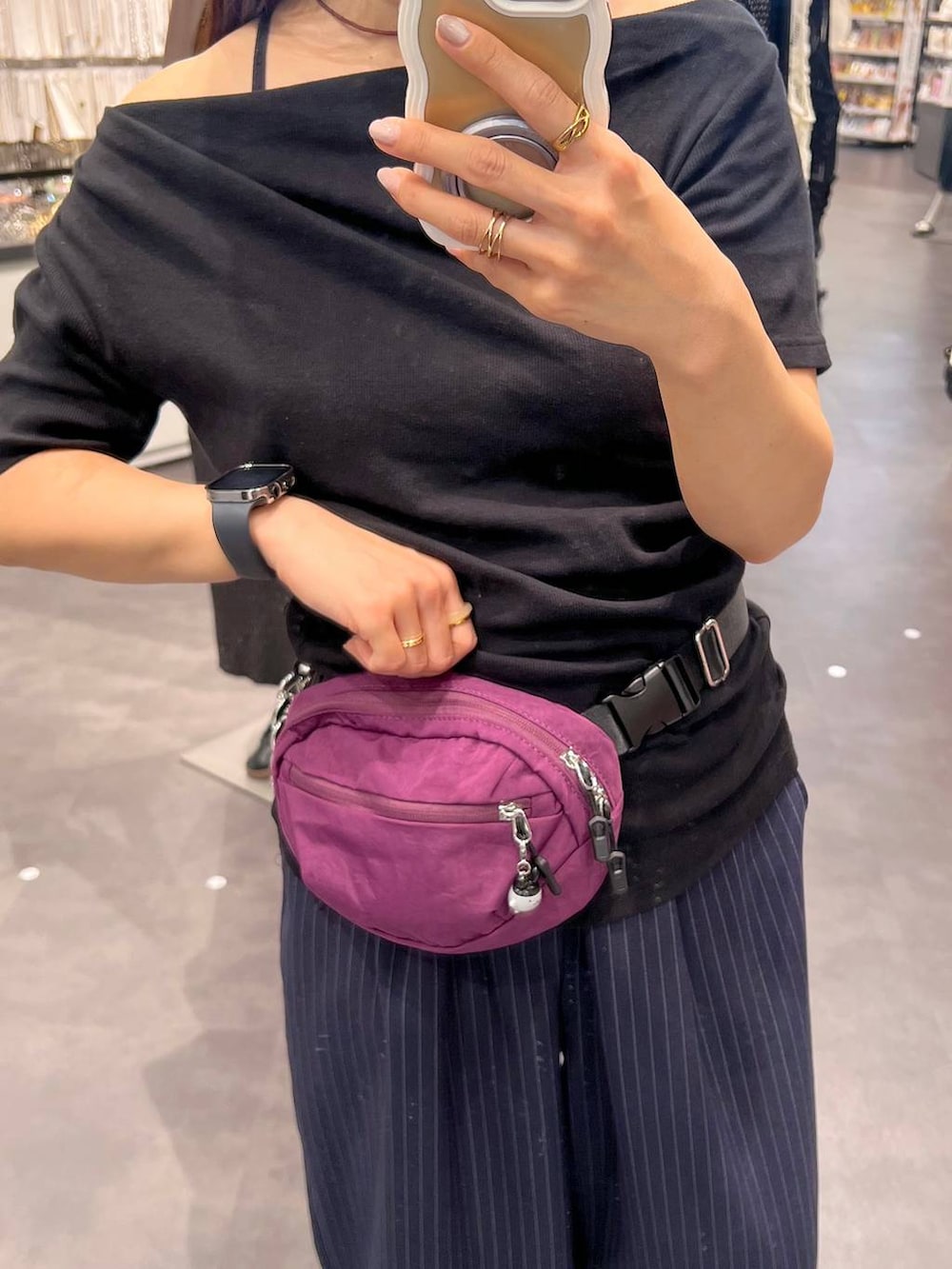 ブルー系のスラックス、パープル系のボディバッグ/ウエストポーチ、ブラック系のTシャツ/カットソーを着用したレディースの夏コーディネートの3枚目の写真