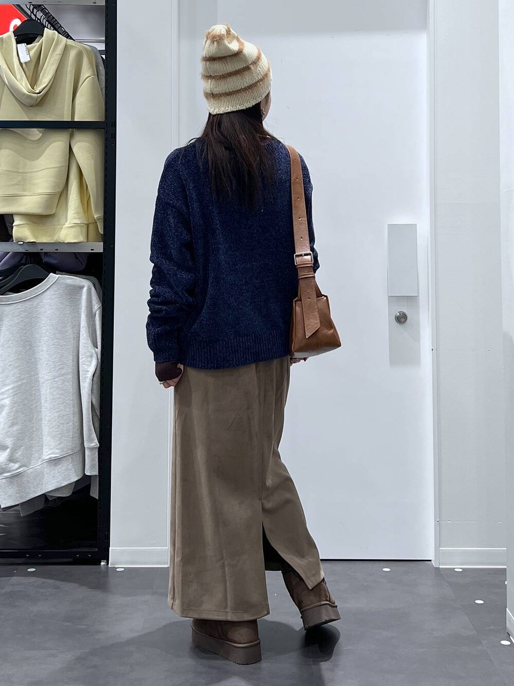 ブラウン系のブーツ、ブルー系のニット/セーター、ブラウン系のスカートを着用したレディースの冬コーディネートの3枚目の写真