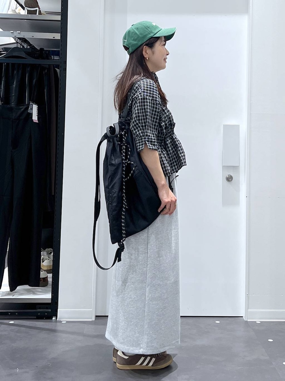 ブラック系のバックパック/リュック、グレー系のスカート、ブラック系のシャツ/ブラウスを着用したレディースの春コーディネートの2枚目の写真