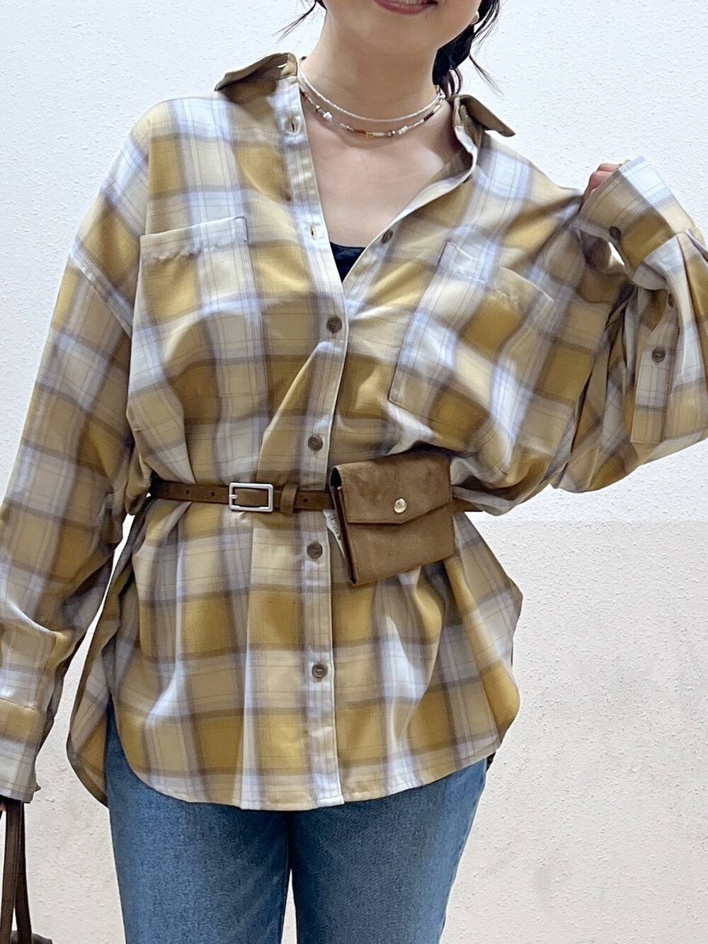 ブルー系のデニムパンツ、イエロー系のシャツ/ブラウス、ブラック系のスニーカーを着用したレディースの夏コーディネートの6枚目の写真