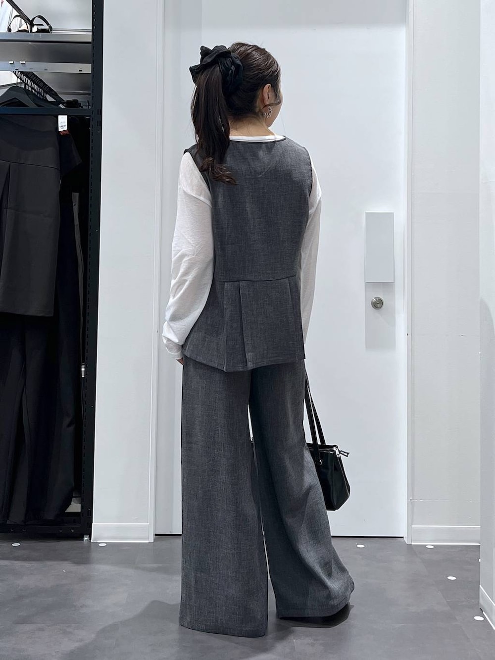 シルバー系のパンプス、ブラック系のハンドバッグ、ブラック系のその他パンツを着用したレディースの春コーディネートの3枚目の写真