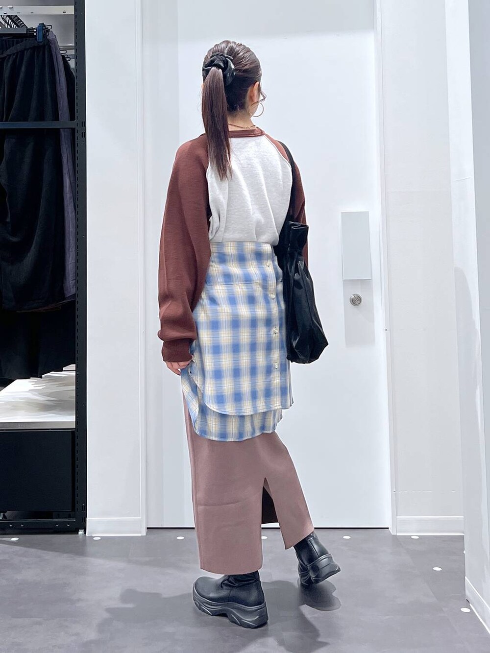 ブラック系のトートバッグ、ブラック系のブーツ、ブラウン系のニット/セーターを着用したレディースの秋コーディネートの3枚目の写真