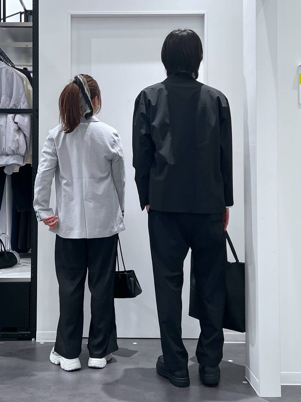 ブラック系のテーラードジャケット、ブラック系のトートバッグ、ホワイト系のTシャツ/カットソーを着用したレディースの春コーディネートの3枚目の写真