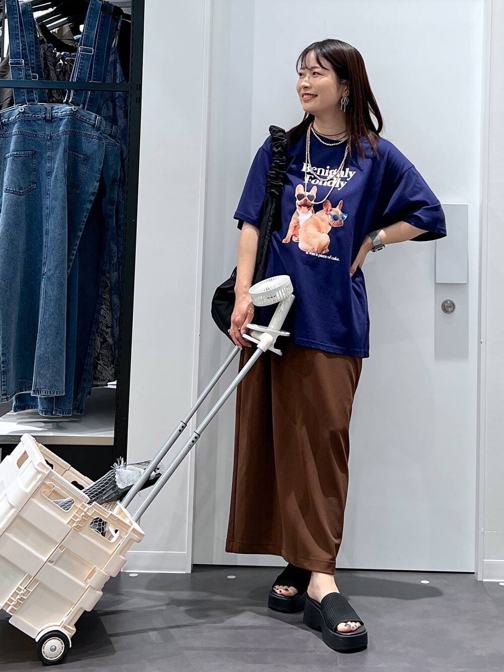 ブラック系のショルダーバッグ、ブルー系のTシャツ/カットソー、グレー系のスポーツグッズを着用したレディースの春コーディネートの3枚目の写真