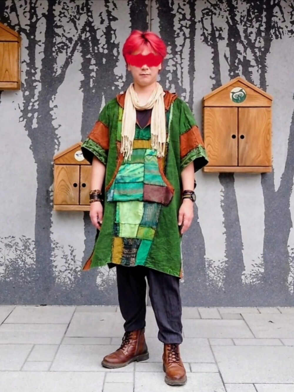 グリーン系のトップス、ブラウン系のブーツを着用したメンズの夏コーディネートの2枚目の写真