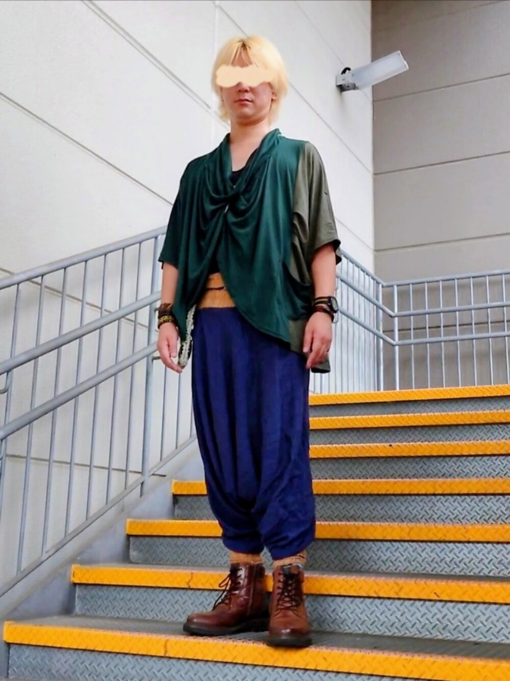 グリーン系のトップス、ブラウン系のブーツを着用したメンズの秋コーディネートの2枚目の写真