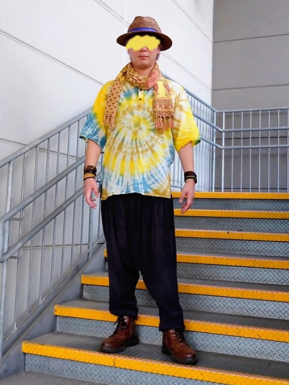 イエロー系のトップス、ブラウン系のブーツ、ブラウン系のハットを着用したメンズの秋コーディネートの2枚目の写真