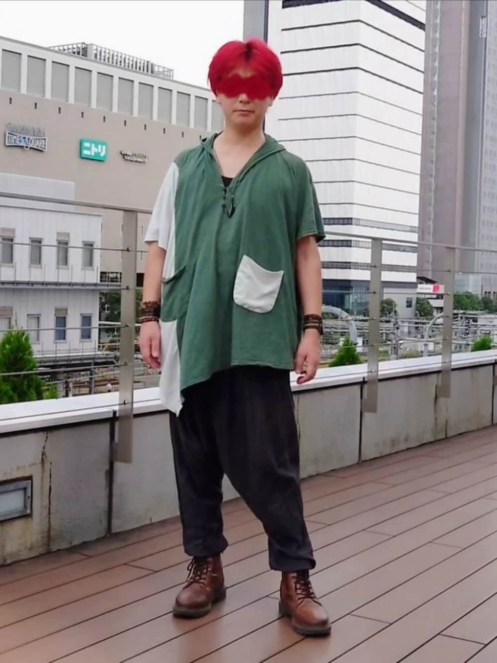 グリーン系のトップス、ブラウン系のブーツを着用したメンズの夏コーディネートの2枚目の写真