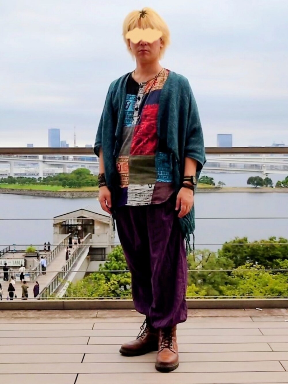 グリーン系のカーディガン/ボレロ、パープル系のパンツ、ブラウン系のブーツを着用したメンズの秋コーディネートの2枚目の写真