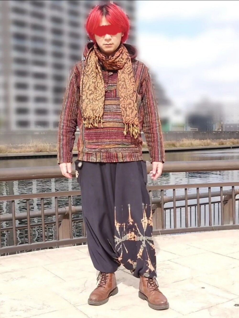 レッド系のマウンテンパーカー、ブラック系のその他パンツ、ブラウン系のブーツを着用したメンズの春コーディネートの2枚目の写真