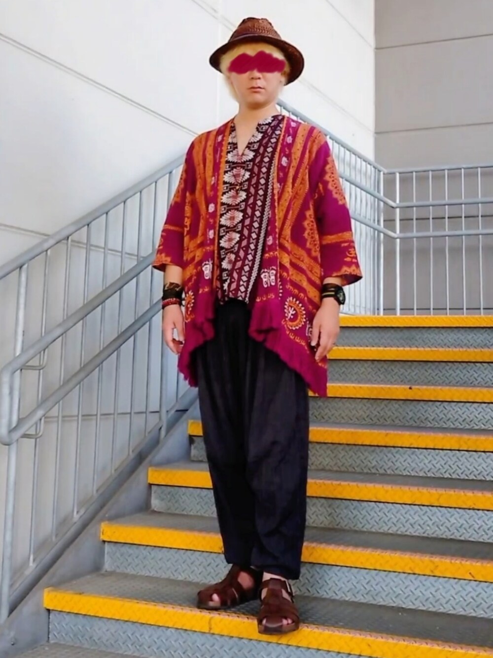 レッド系のトップス、ブラウン系のサンダル、ブラウン系のハットを着用したメンズの秋コーディネートの2枚目の写真