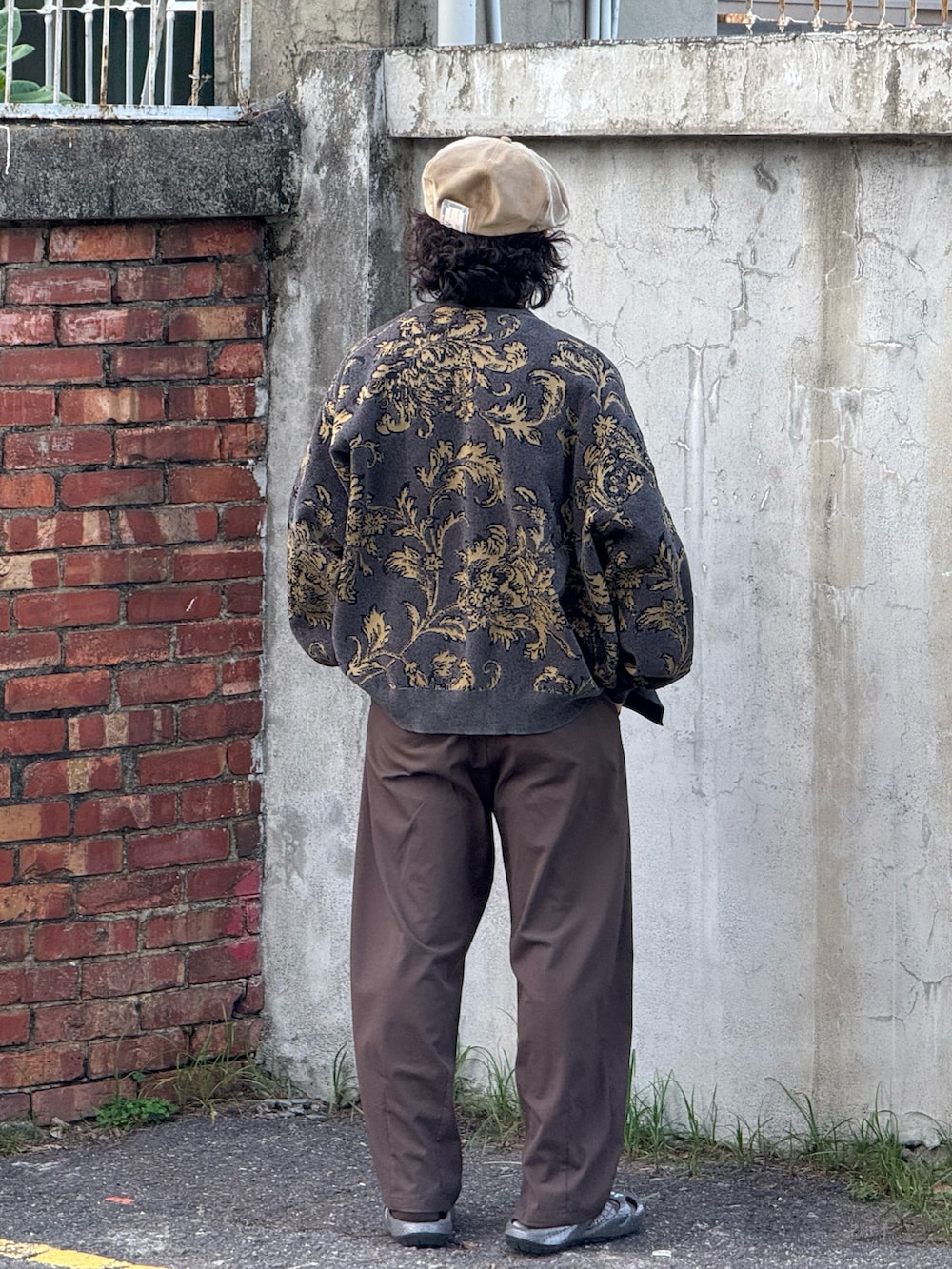 グレー系のカーディガン/ボレロ、ブラック系のTシャツ/カットソー、ブラウン系のパンツを着用したメンズの秋コーディネートの2枚目の写真