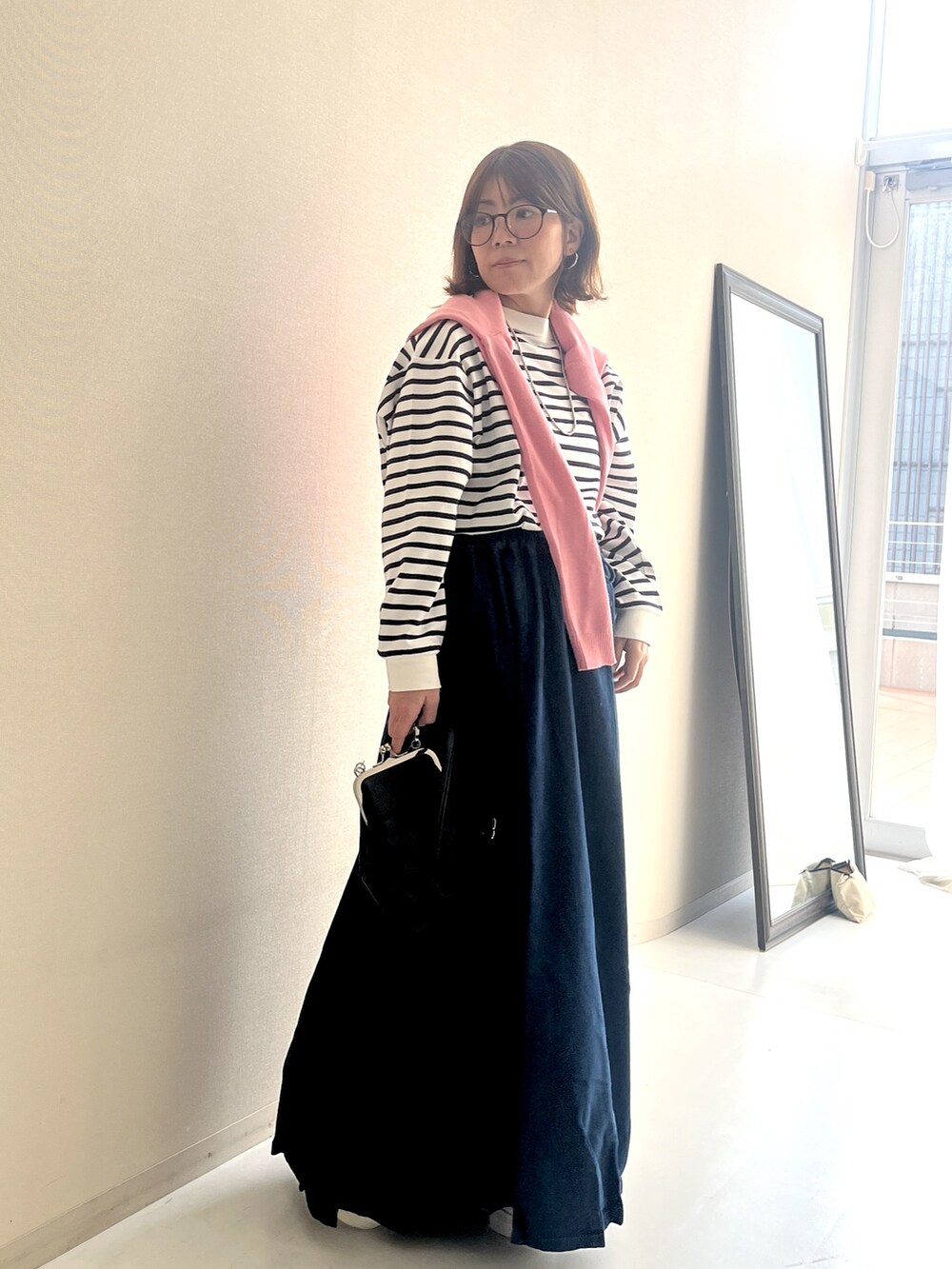 ホワイト系のTシャツ/カットソー、ブルー系のデニムスカート、ピンク系のカーディガン/ボレロを着用したレディースの冬コーディネートの7枚目の写真