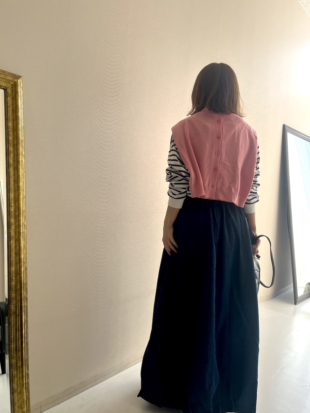 ホワイト系のTシャツ/カットソー、ブルー系のデニムスカート、ピンク系のカーディガン/ボレロを着用したレディースの冬コーディネートの4枚目の写真