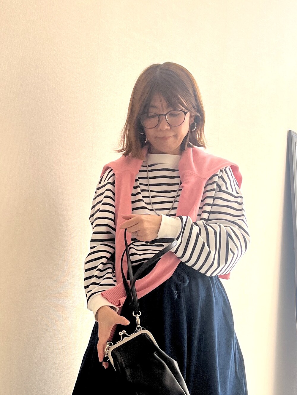 ホワイト系のTシャツ/カットソー、ブルー系のデニムスカート、ピンク系のカーディガン/ボレロを着用したレディースの冬コーディネートの5枚目の写真