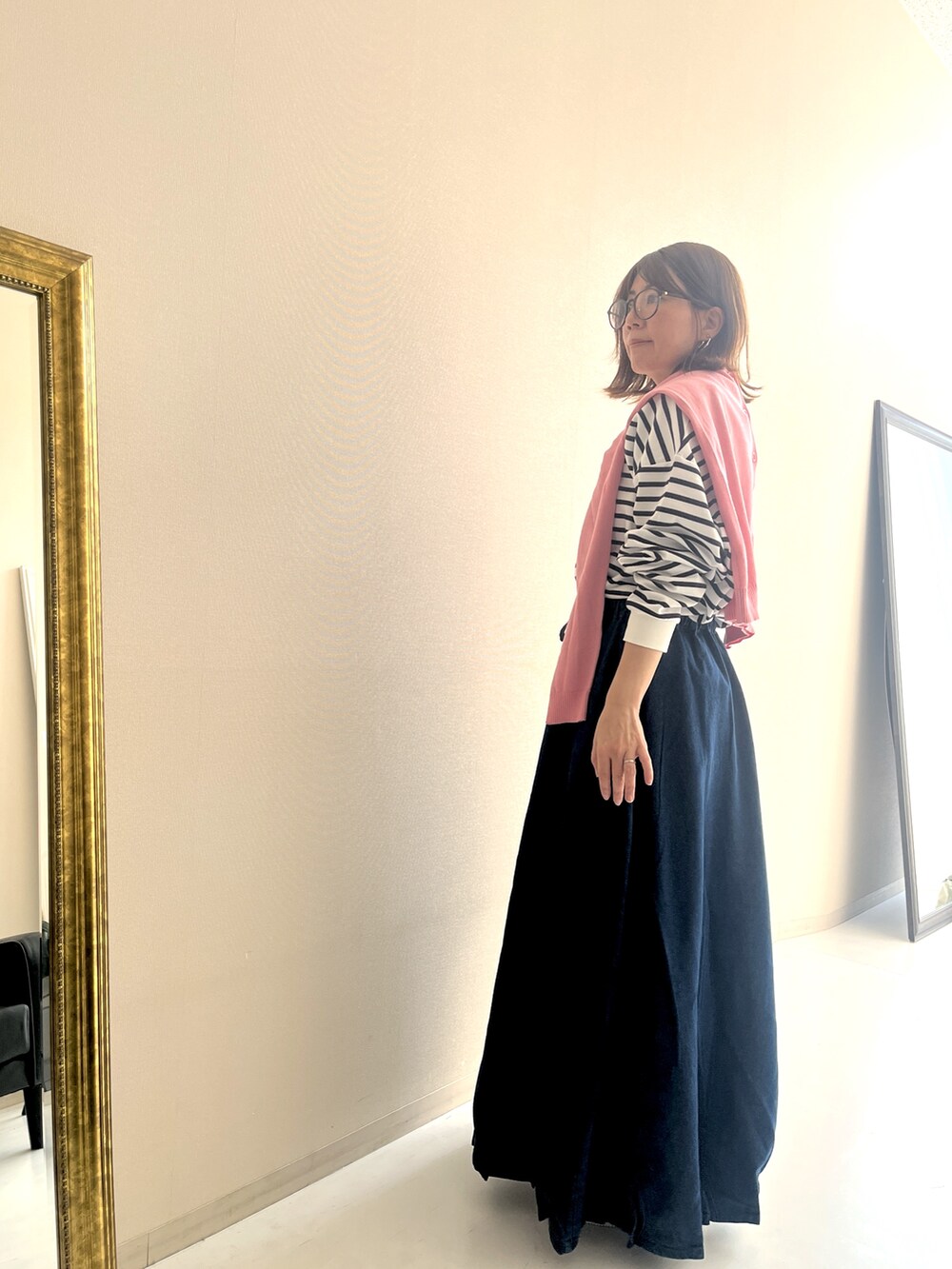 ホワイト系のTシャツ/カットソー、ブルー系のデニムスカート、ピンク系のカーディガン/ボレロを着用したレディースの冬コーディネートの3枚目の写真