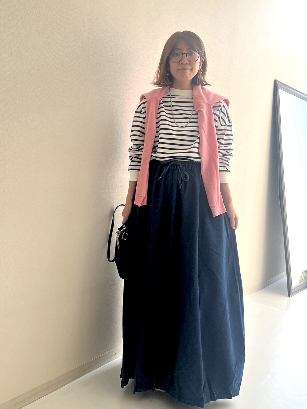 ホワイト系のTシャツ/カットソー、ブルー系のデニムスカート、ピンク系のカーディガン/ボレロを着用したレディースの冬コーディネートの8枚目の写真