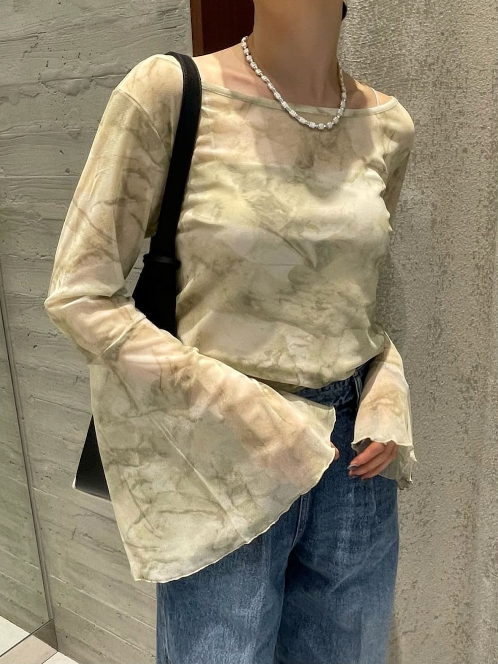 ブルー系のデニムパンツ、ベージュ系のTシャツ/カットソー、ホワイト系のトートバッグを着用したレディースの夏コーディネートの3枚目の写真
