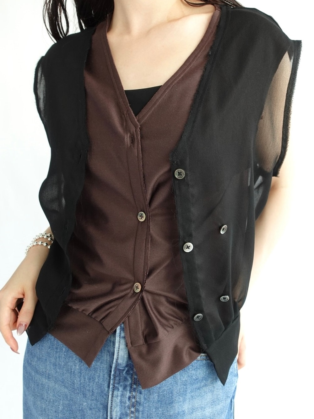 ブラック系のベスト、ブルー系のデニムスカートを着用したレディースの夏コーディネートの3枚目の写真