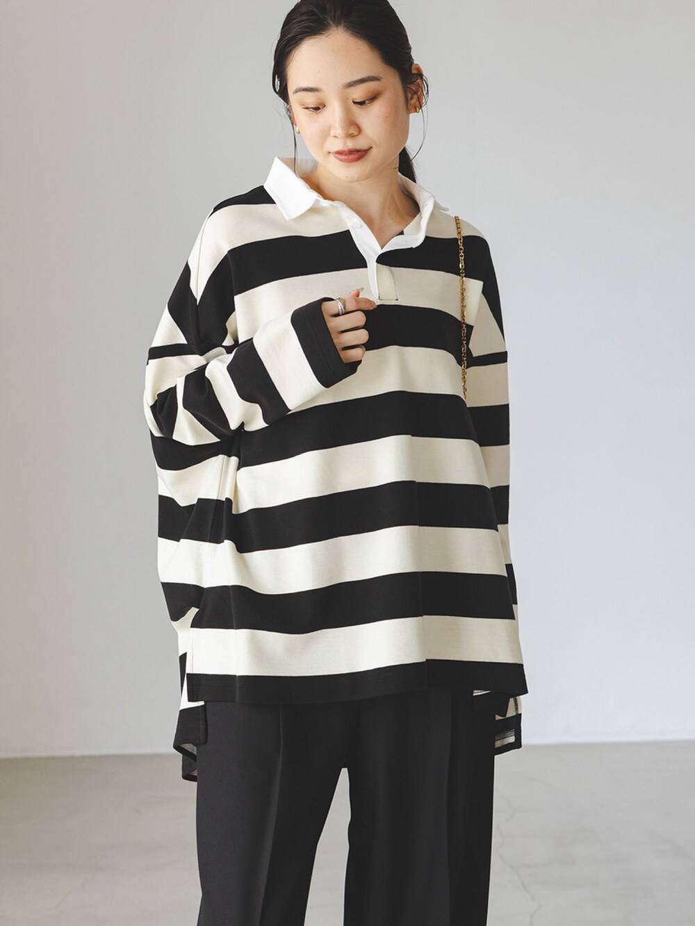 ホワイト系のTシャツ/カットソー、ブラック系のスラックス、ベージュ系のサンダルを着用したレディースの秋コーディネートの4枚目の写真