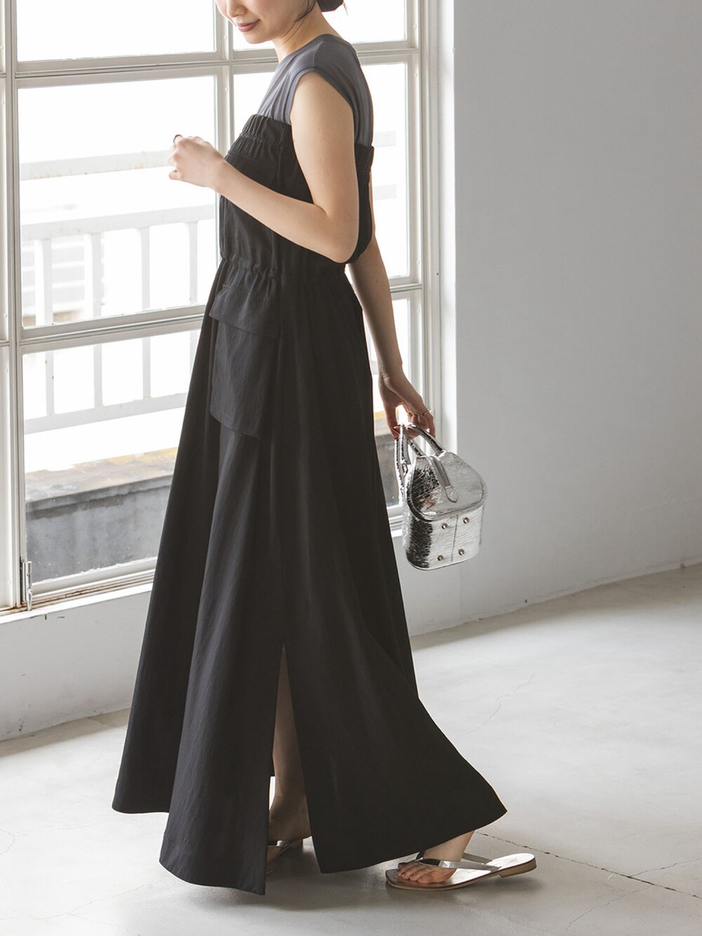 グレー系のTシャツ/カットソー、ブラック系のワンピース、シルバー系のサンダルを着用したレディースの夏コーディネートの3枚目の写真