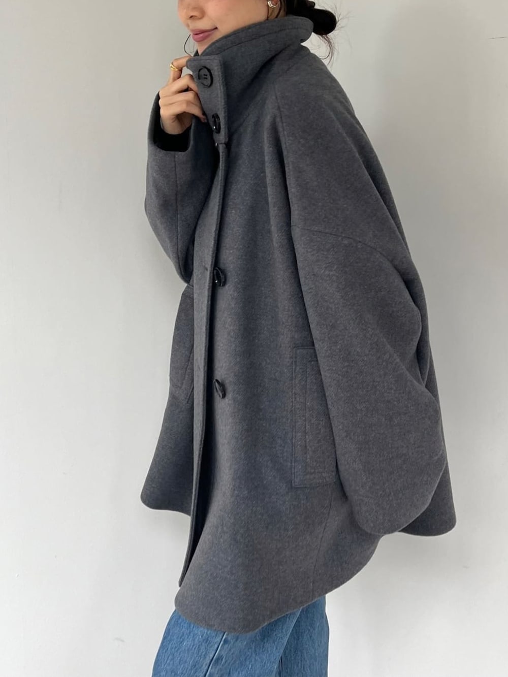 グレー系のその他アウター、シルバー系のパンプス、ブルー系のデニムパンツを着用したレディースの冬コーディネートの3枚目の写真