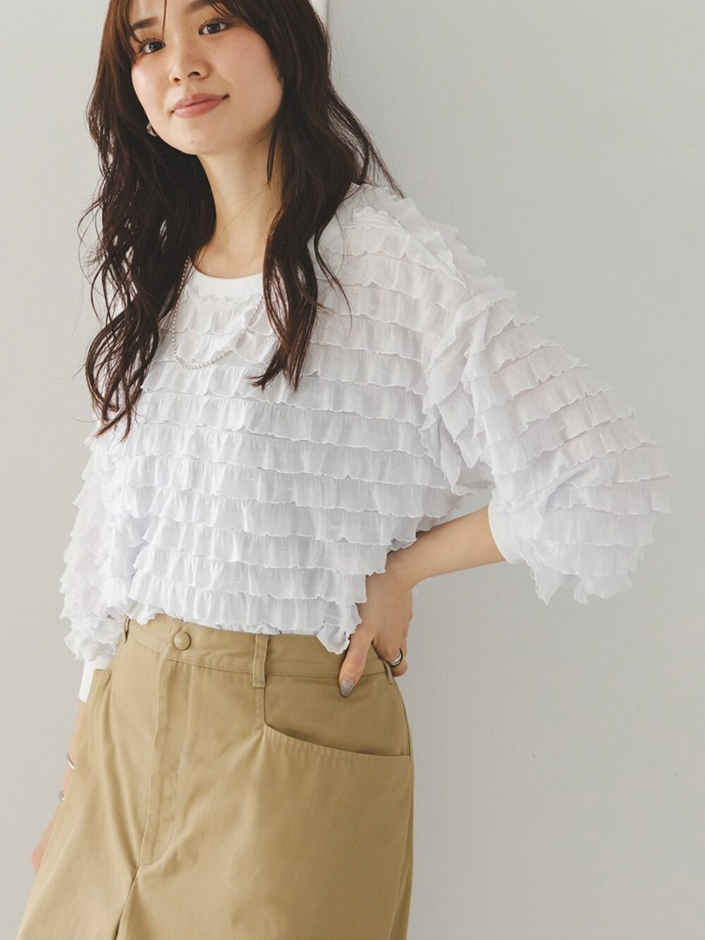 ホワイト系のTシャツ/カットソー、ベージュ系のチノパンツ、ベージュ系のショルダーバッグを着用したレディースの夏コーディネートの2枚目の写真