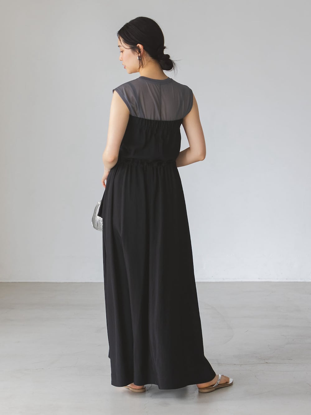 グレー系のTシャツ/カットソー、ブラック系のワンピース、シルバー系のサンダルを着用したレディースの夏コーディネートの2枚目の写真