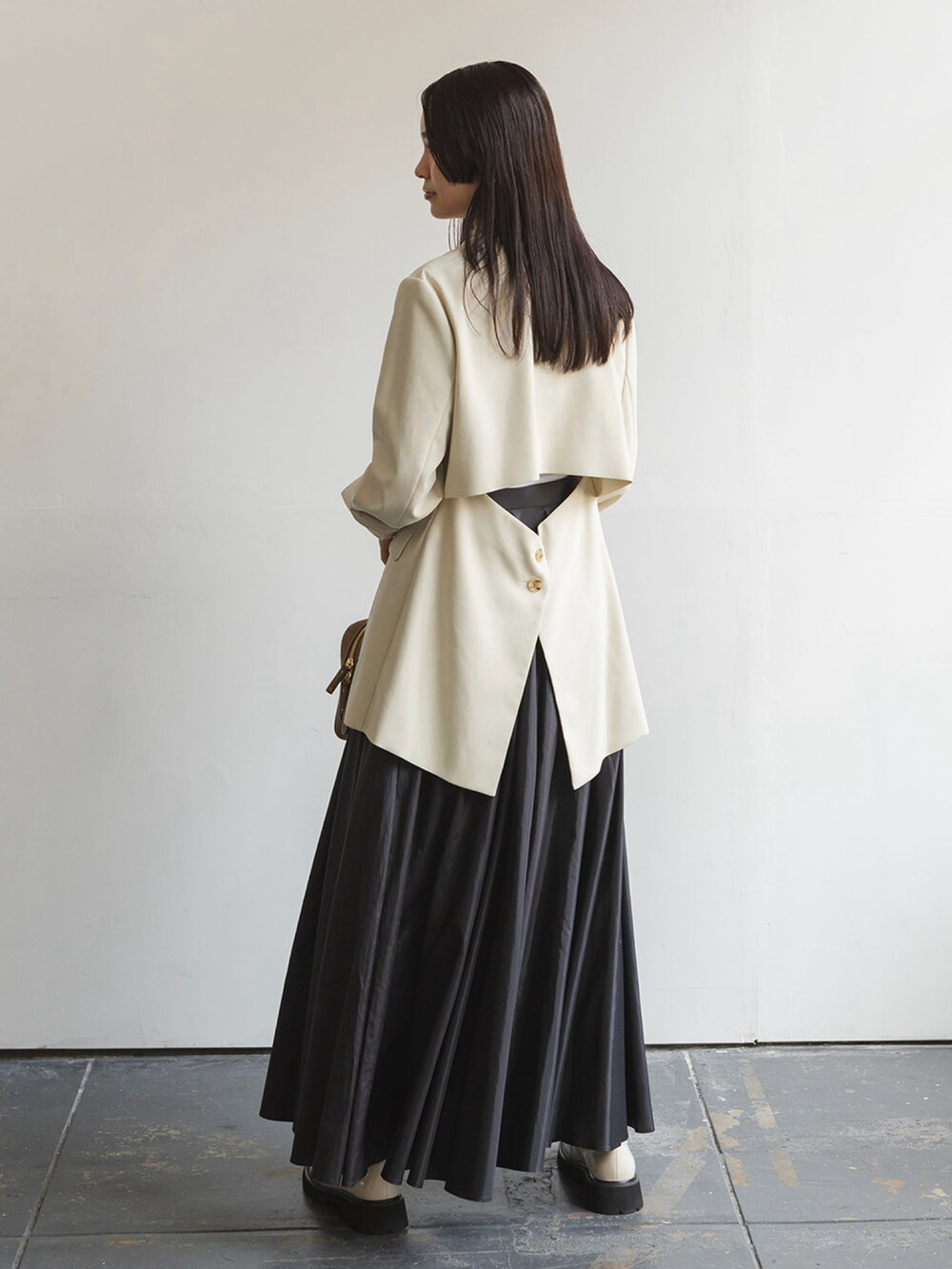 ベージュ系のテーラードジャケット、ブラック系のスカートを着用したレディースの夏コーディネートの2枚目の写真