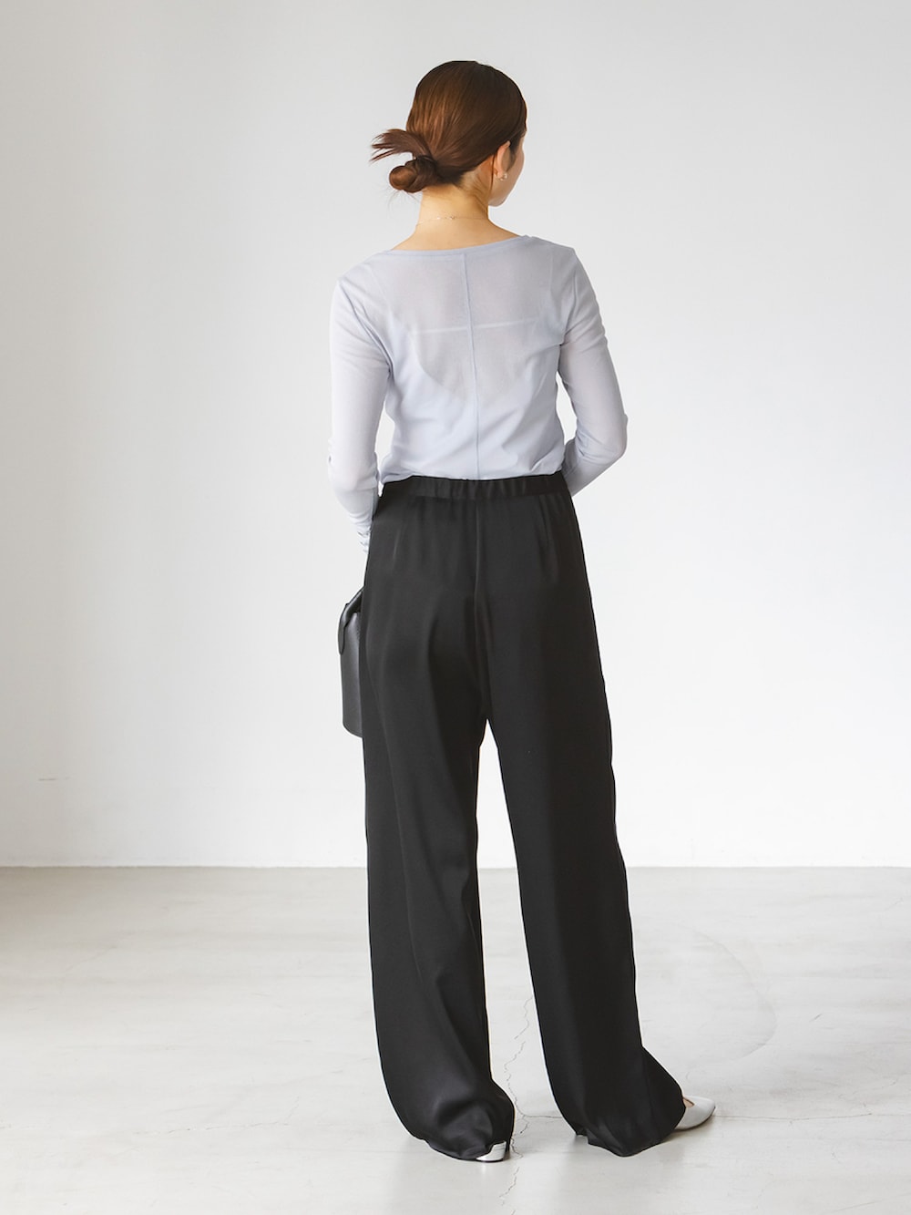 ブルー系のTシャツ/カットソー、ブラック系のスラックス、ブラック系のショルダーバッグを着用したレディースの春コーディネートの3枚目の写真