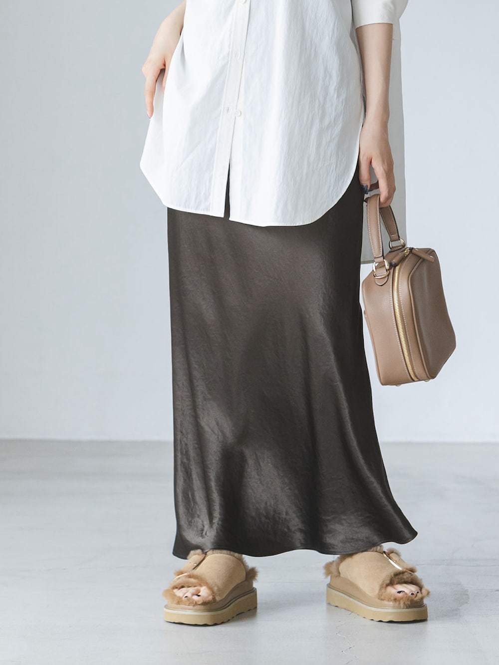 ブラウン系のスカート、ベージュ系のサンダル、ホワイト系のシャツ/ブラウスを着用したレディースの夏コーディネートの3枚目の写真