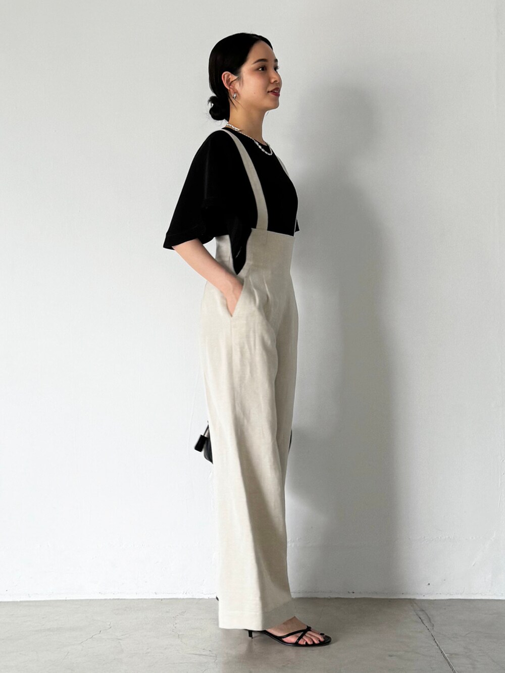 ベージュ系のその他パンツ、ブラック系のシャツ/ブラウス、ブラック系のサンダルを着用したレディースの夏コーディネートの2枚目の写真