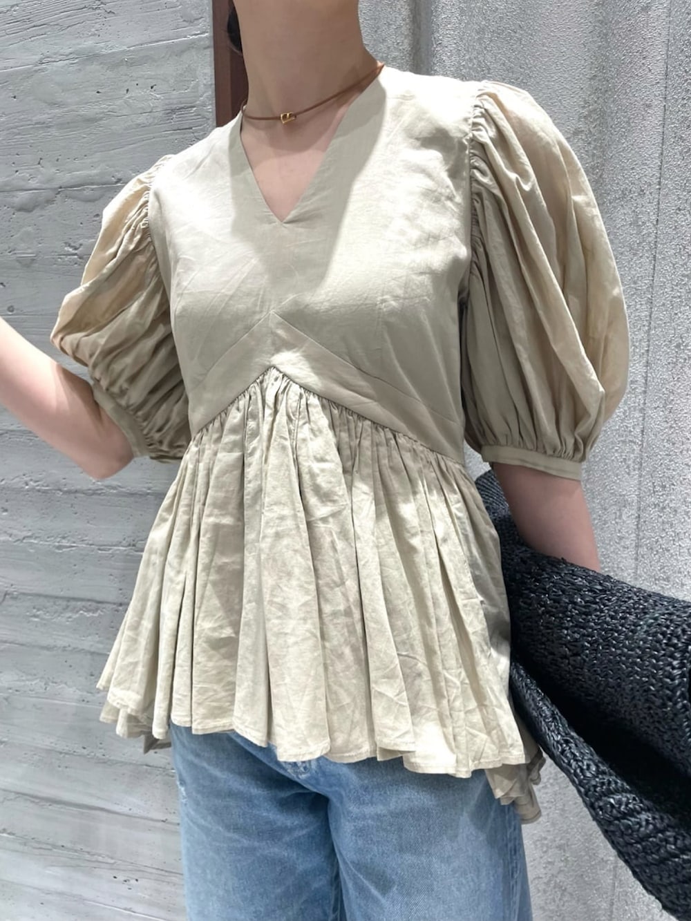 ベージュ系のシャツ/ブラウス、ブルー系のデニムパンツ、ブラック系のサンダルを着用したレディースの春コーディネートの3枚目の写真