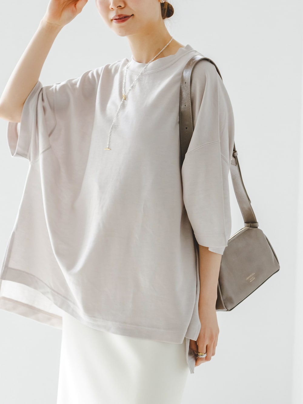 ベージュ系のTシャツ/カットソー、ホワイト系のスカート、グレー系のショルダーバッグを着用したレディースの春コーディネートの4枚目の写真