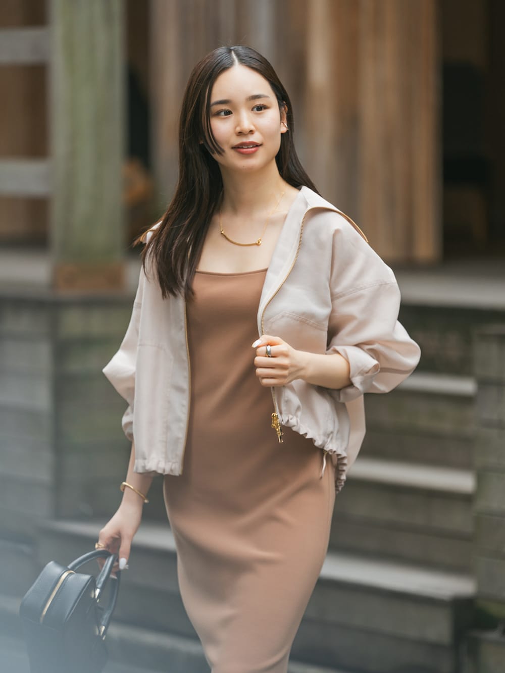 ベージュ系のその他アウター、イエロー系のワンピース、ブラック系のサンダルを着用したレディースの春コーディネートの3枚目の写真