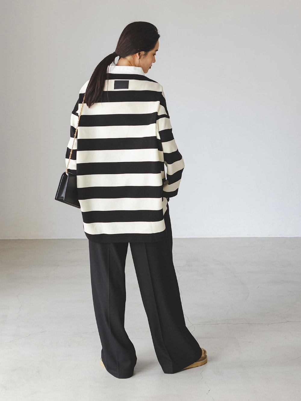 ホワイト系のTシャツ/カットソー、ブラック系のスラックス、ベージュ系のサンダルを着用したレディースの秋コーディネートの3枚目の写真