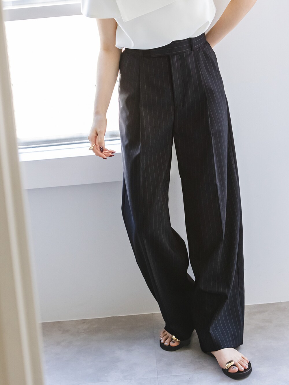 ブルー系のスラックス、ホワイト系のシャツ/ブラウス、ブラック系のショルダーバッグを着用したレディースの春コーディネートの3枚目の写真