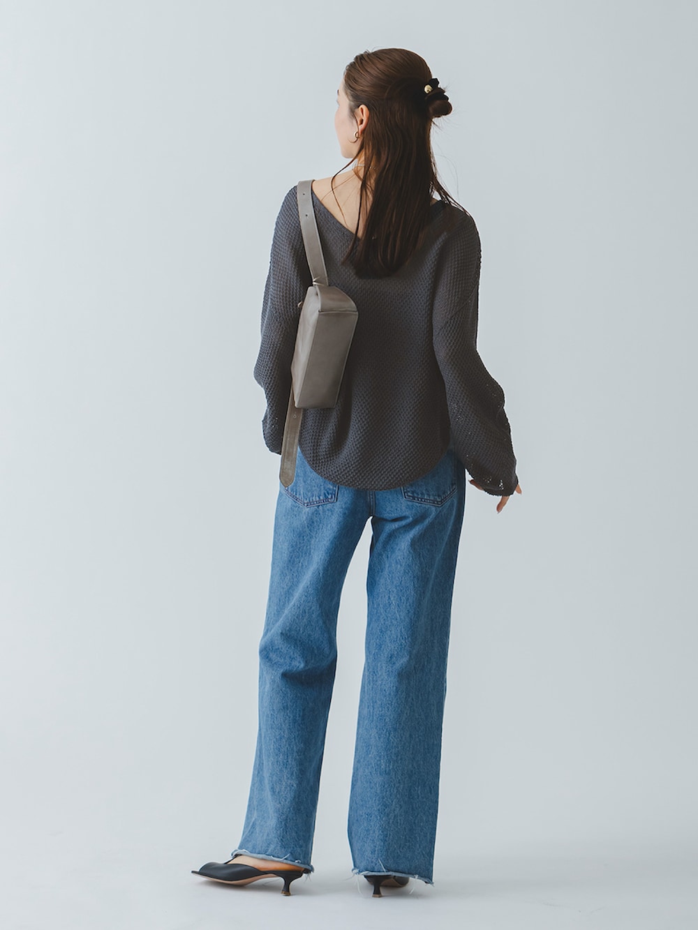 グレー系のニット/セーター、ブルー系のデニムパンツ、ブラック系のサンダルを着用したレディースの春コーディネートの4枚目の写真