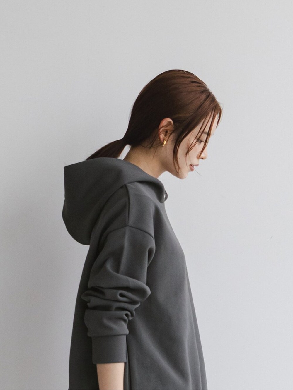 グレー系のスウェット、ホワイト系のスラックス、ブラック系のパンプスを着用したレディースの秋コーディネートの3枚目の写真