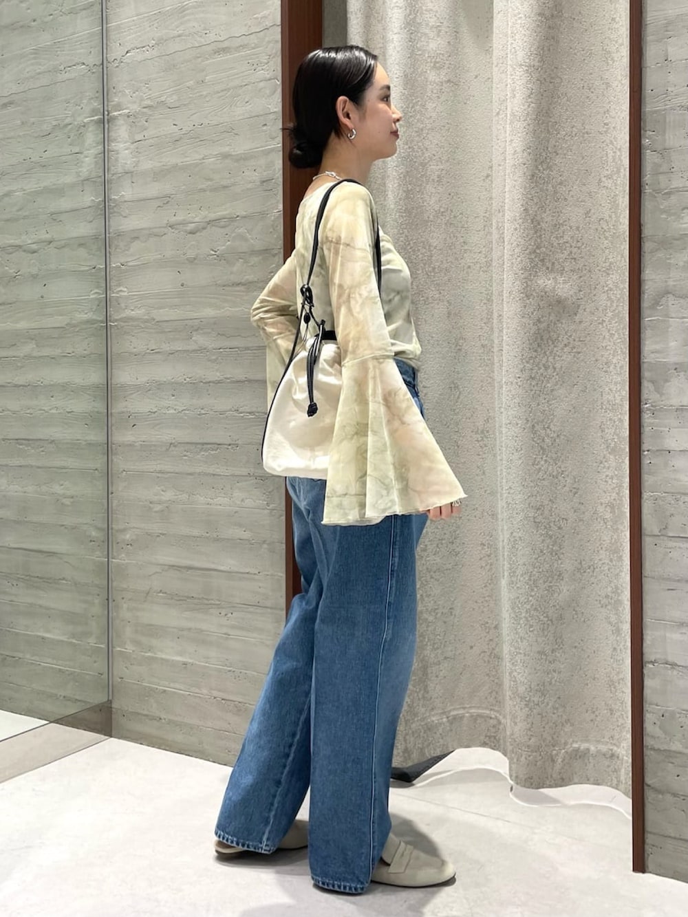 ブルー系のデニムパンツ、ベージュ系のTシャツ/カットソー、ホワイト系のトートバッグを着用したレディースの夏コーディネートの2枚目の写真
