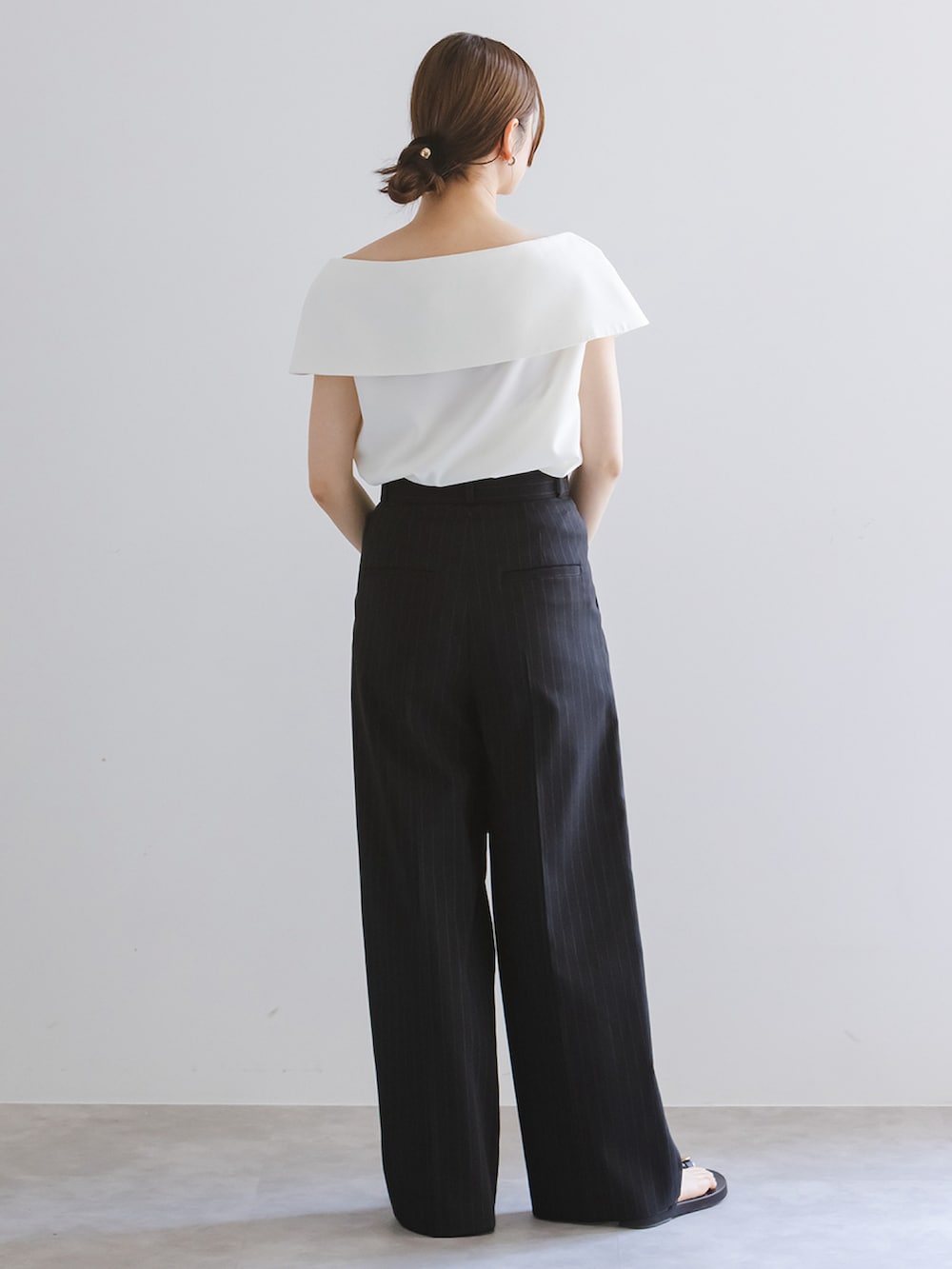 ブルー系のスラックス、ホワイト系のシャツ/ブラウス、ブラック系のショルダーバッグを着用したレディースの春コーディネートの2枚目の写真