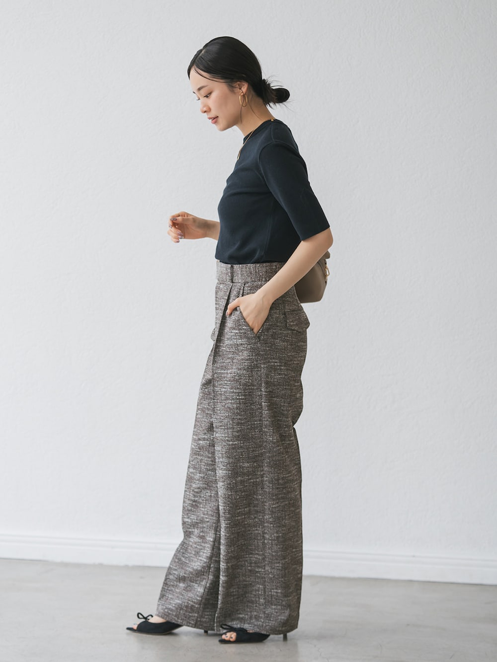 ブラック系のスラックス、ブルー系のニット/セーターを着用したレディースの秋コーディネートの2枚目の写真