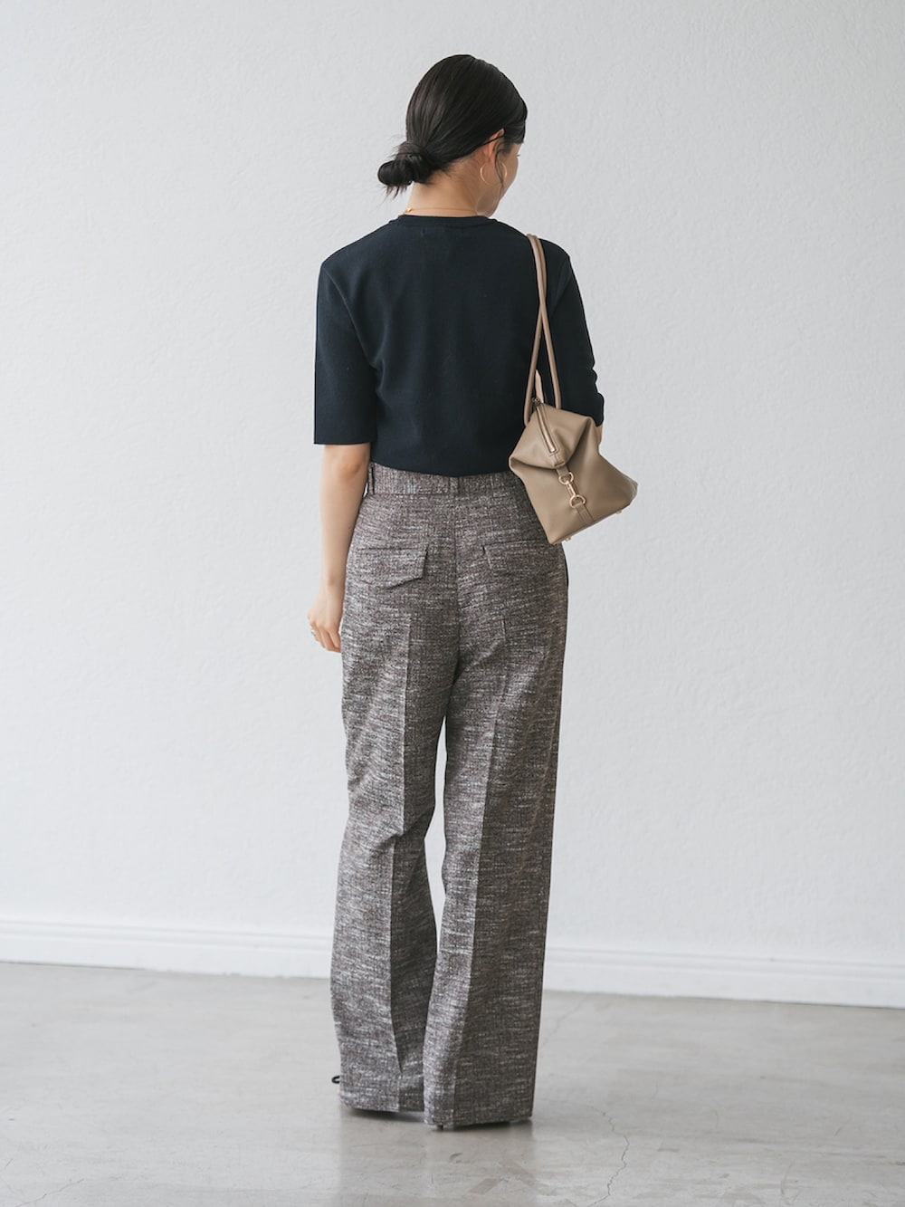 ブラック系のスラックス、ブルー系のニット/セーターを着用したレディースの秋コーディネートの3枚目の写真