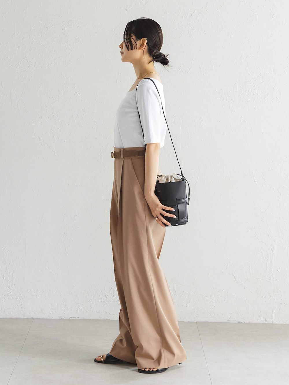 ホワイト系のTシャツ/カットソー、ブラウン系のスラックス、ブラック系のサンダルを着用したレディースの春コーディネートの2枚目の写真