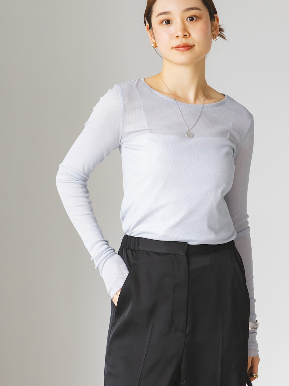 ブルー系のTシャツ/カットソー、ブラック系のスラックス、ブラック系のショルダーバッグを着用したレディースの春コーディネートの4枚目の写真