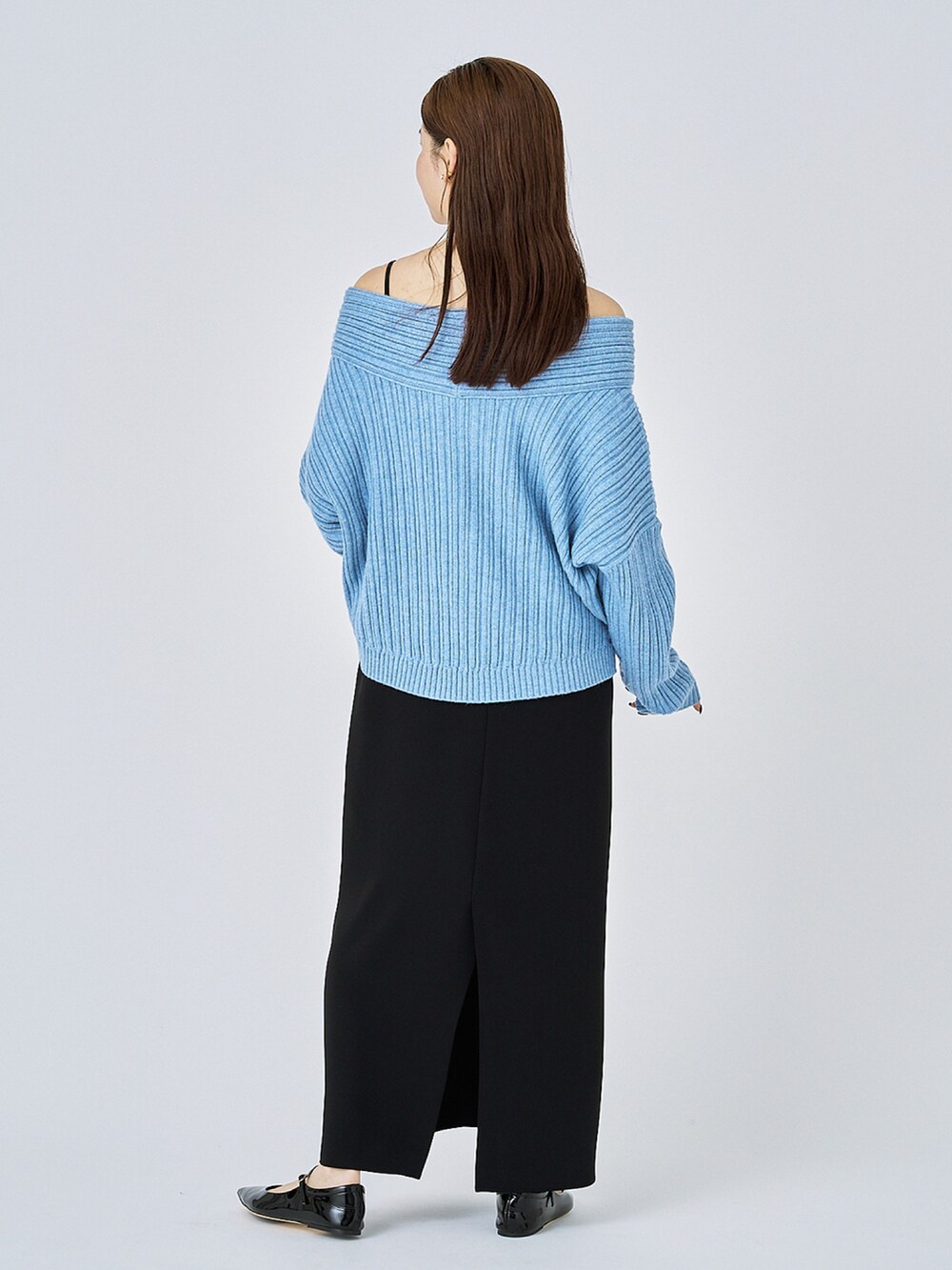 ブルー系のニット/セーター、ブラック系のワンピース、ブラック系のパンプスを着用したレディースの冬コーディネートの2枚目の写真