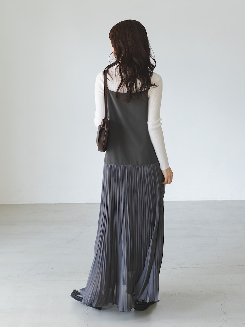 グレー系のワンピース、ホワイト系のニット/セーター、ブラウン系のショルダーバッグを着用したレディースの秋コーディネートの2枚目の写真